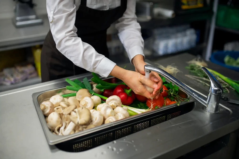 close-up-of-cook-washing-vegetables-in-sink-in-com-2022-02-02-06-28-25-utc.webp