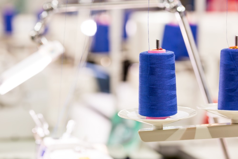 spools-of-blue-threads-on-sewing-machine-factory-2023-11-27-05-22-30-utc.jpg